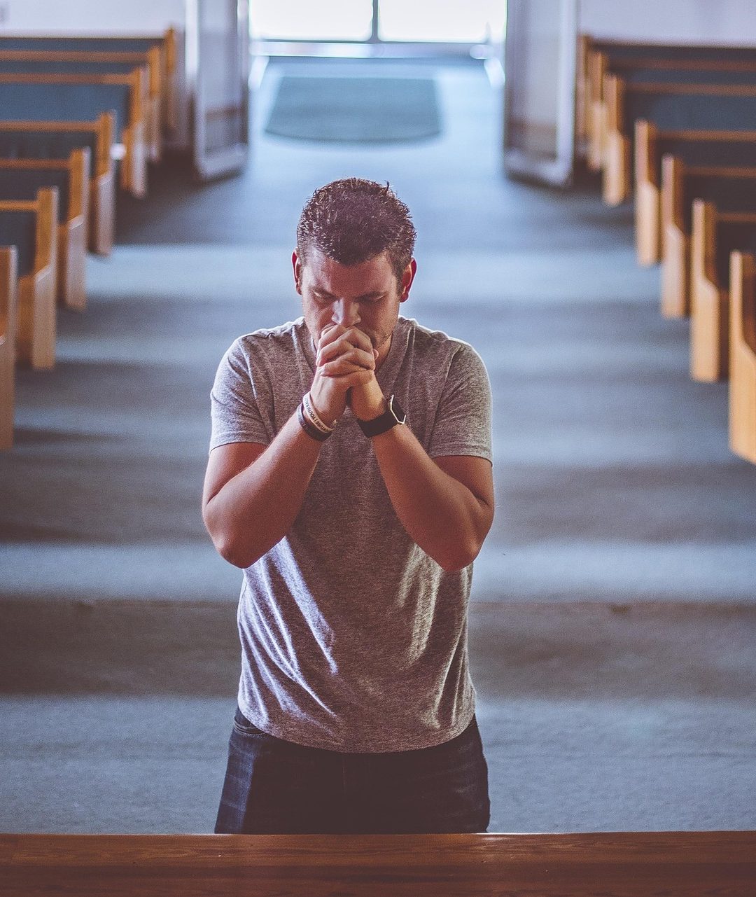 A man praying alone in an empty church