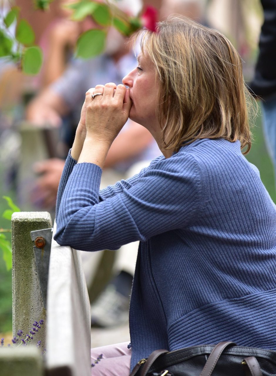 A woman lost in worried thought among other people