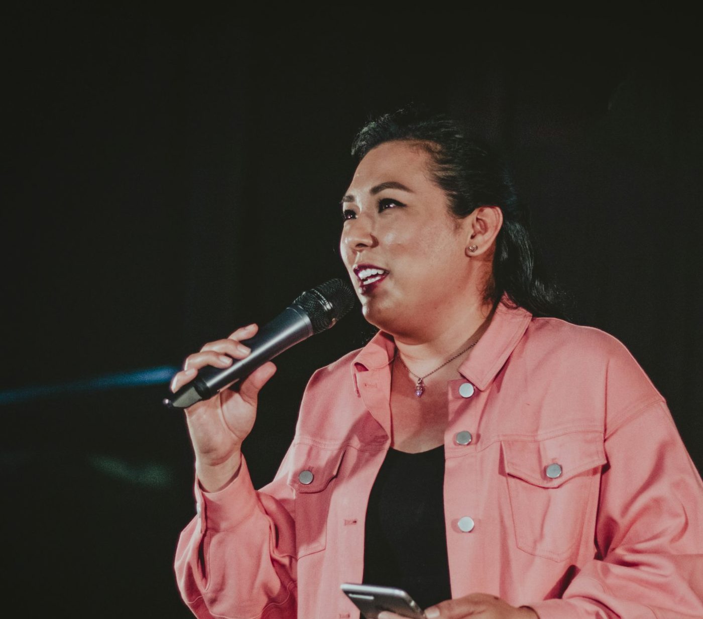 A woman speaking confidently on stage with a microphone